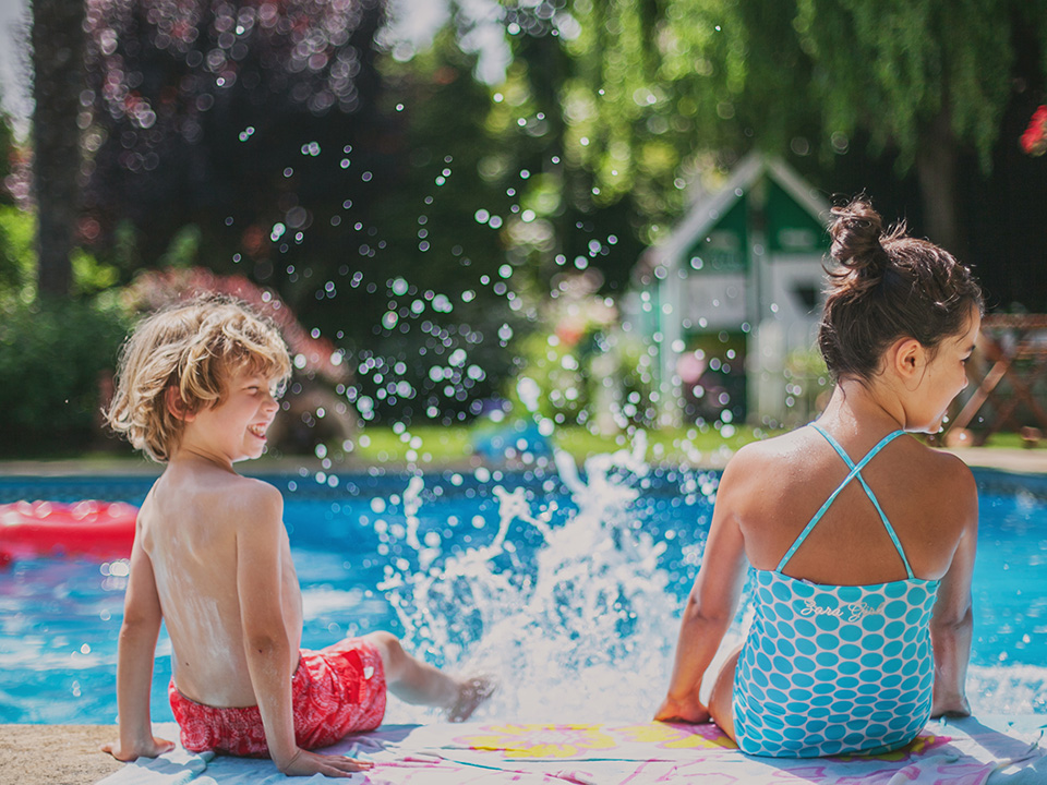 Children splashing and playing in a pool on a summer day