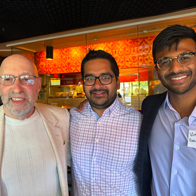 Three attendees posing together for a photo during a residency celebration dinner
