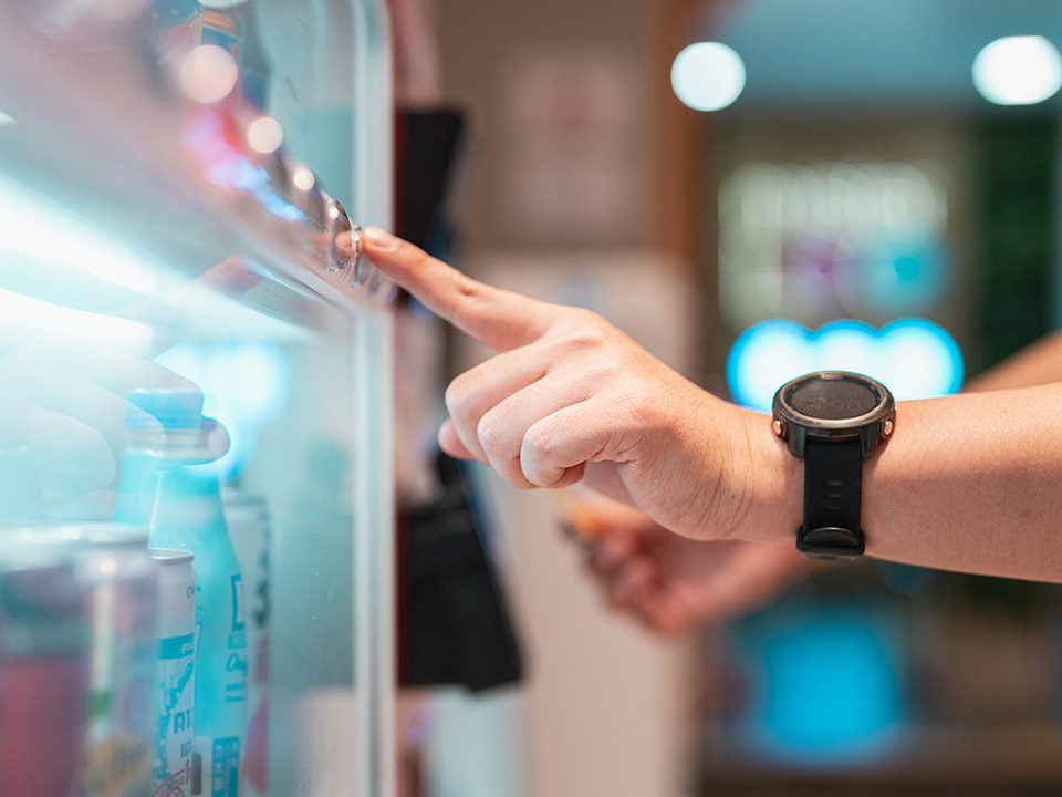 customer pushing a button to select food from a vending machine in the hospital