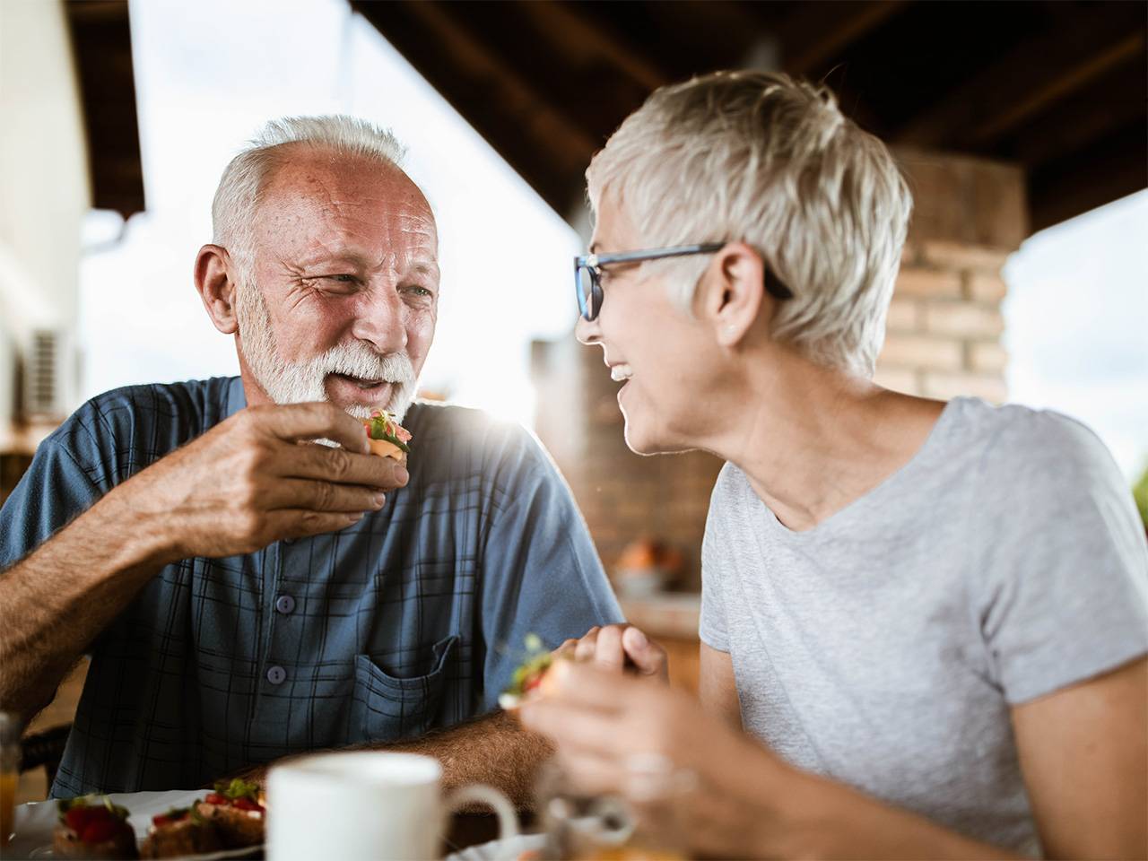 Older adults sharing a healthy meal together at home, enjoying fresh food and social connection while aging well.