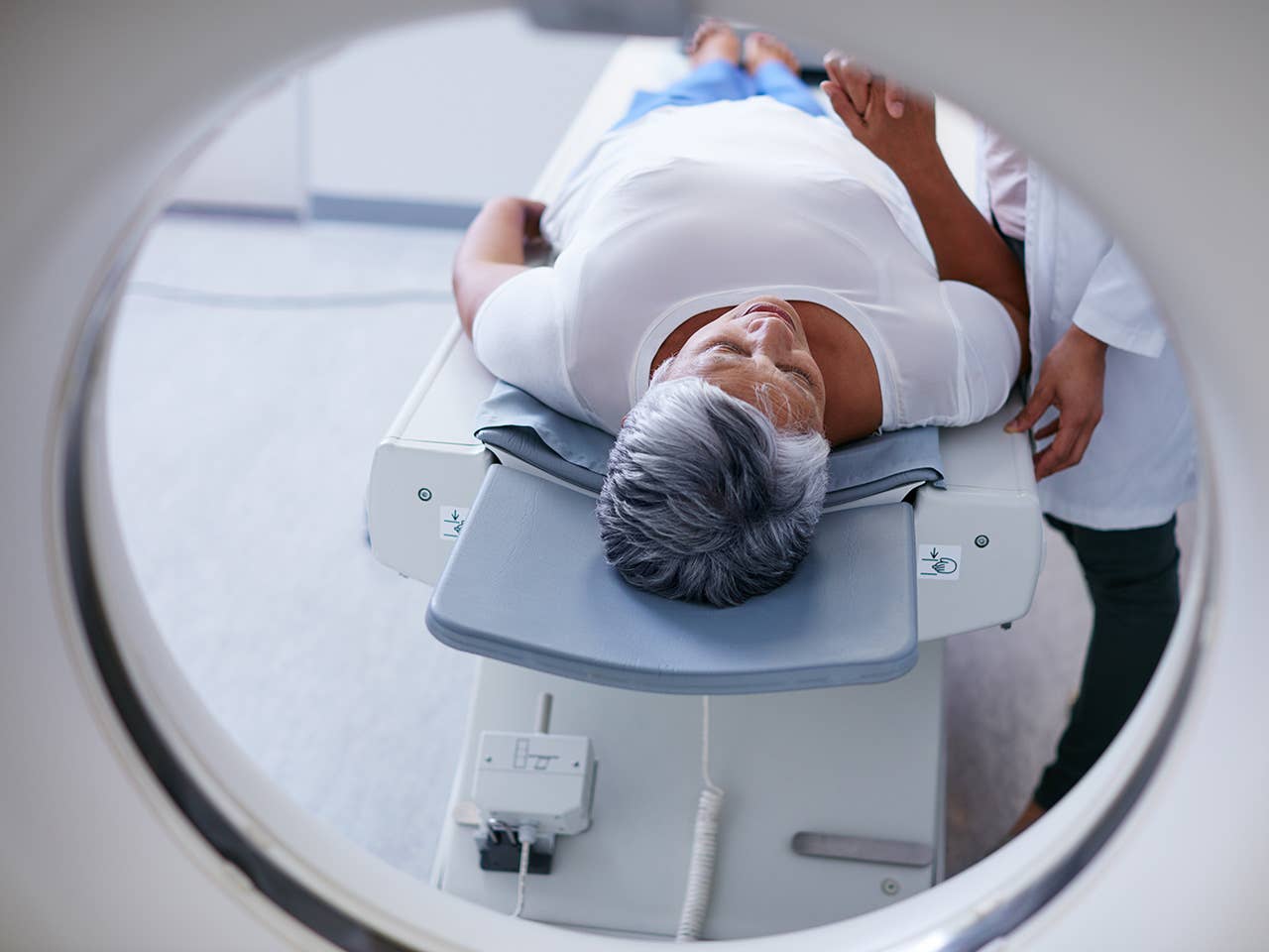 Woman with short grey hair comfortably lies down for a CT scan at a Corewell Health imaging facility