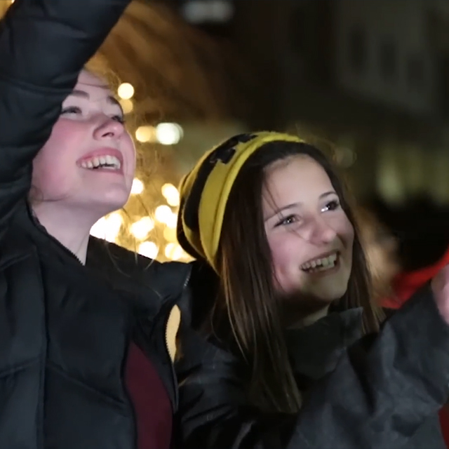 Two girls smiling and waving at Corewell Health Children's Moonbeams for Sweet Dreams.