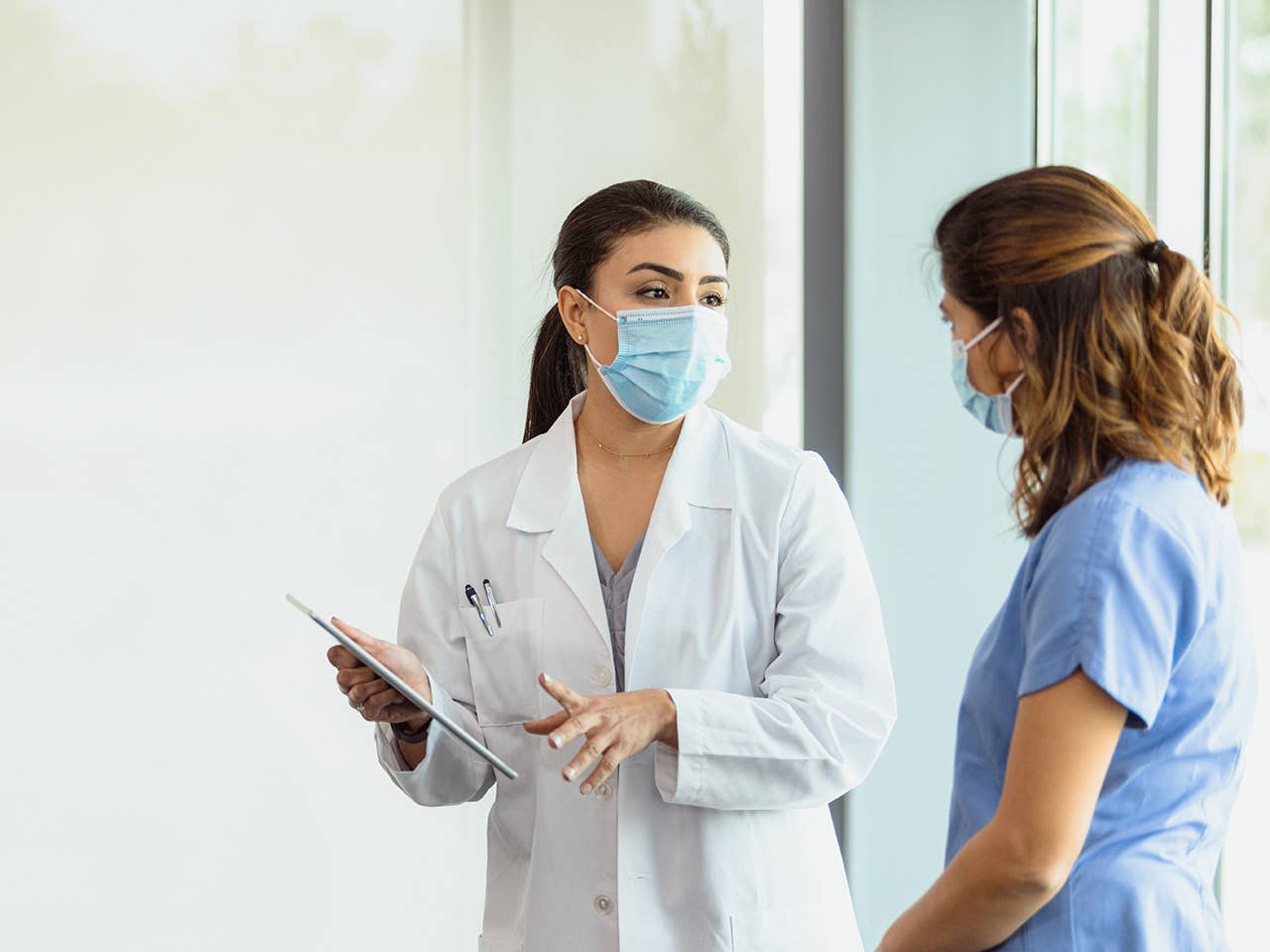 Two healthcare providers talking.