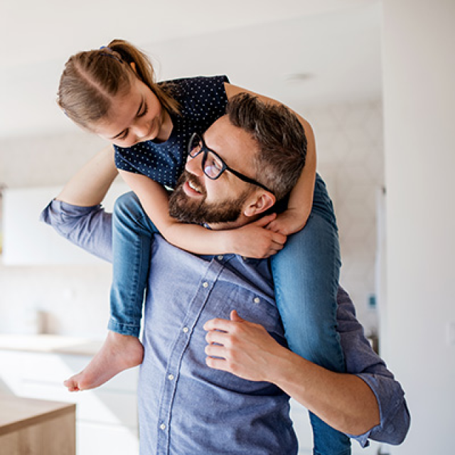 father holding his daughter in the kitchen