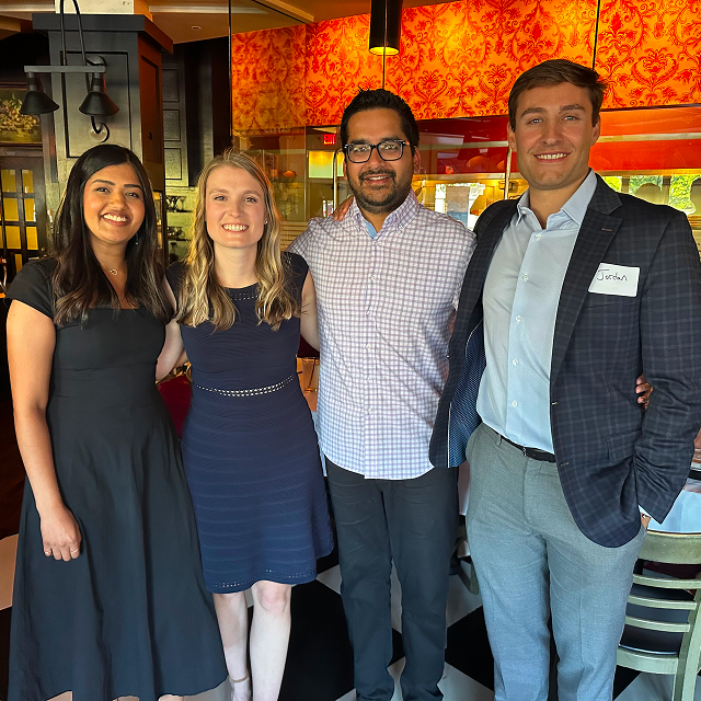 Four residents posing together for a photo during a residency celebration dinner