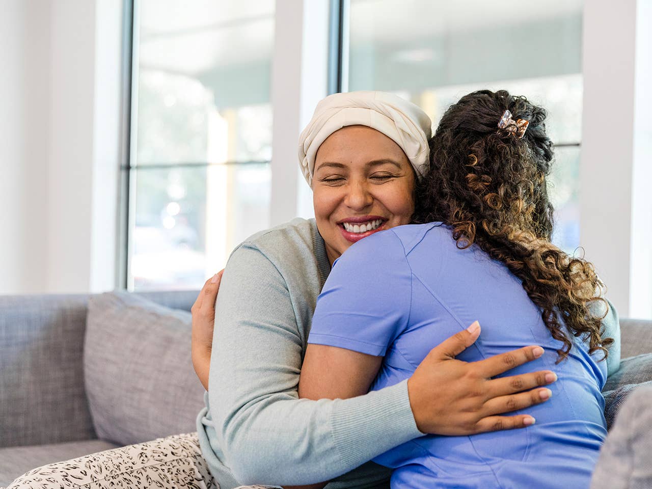 Smiling hospice patient hugs a Corewell Health caregiver