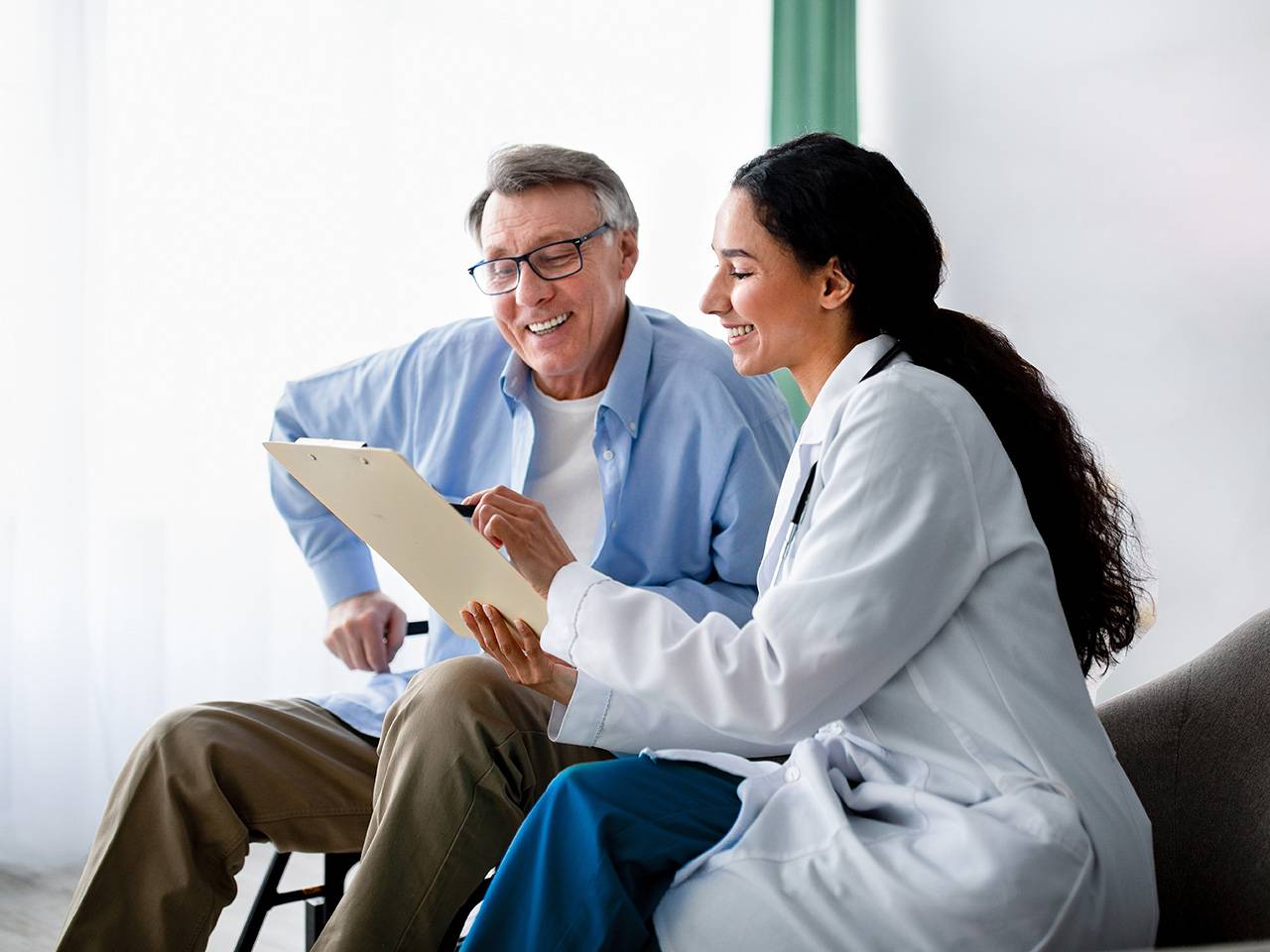 Female doctor walking a patient through something on a tablet