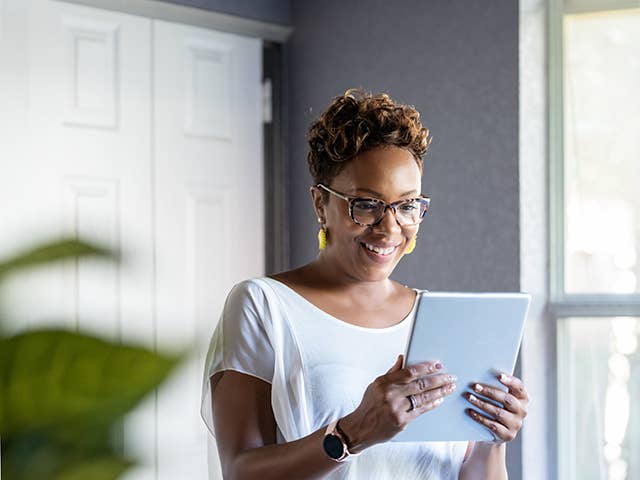 Woman uses mobile device to access Corewell Health MyChart account