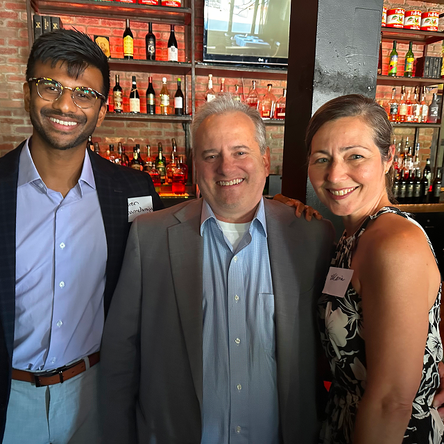 Three attendees posing together for a photo at a residency celebration dinner