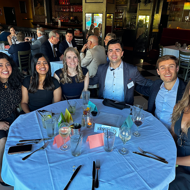 Attendees seated around a restaurant table during a residency celebration dinner