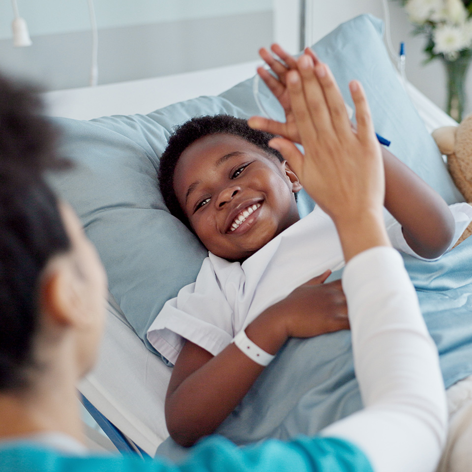 A woman and a child are joyfully giving each other high fives in a playful interaction.