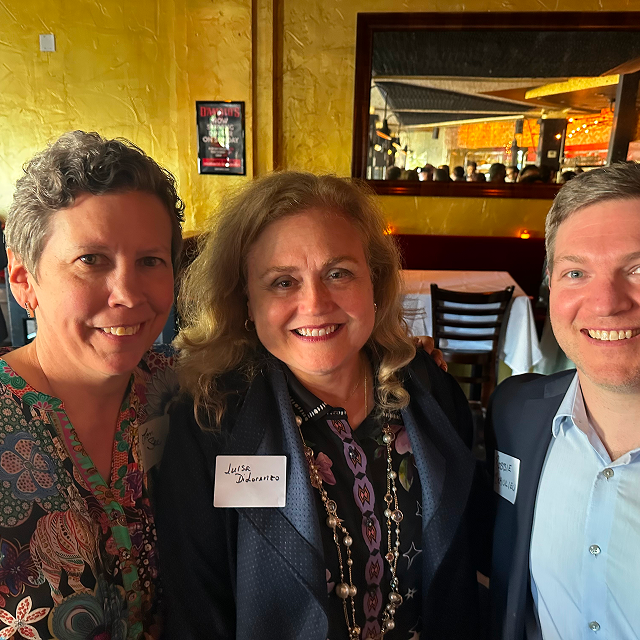 Three attendees posing together for a photo at a residency celebration dinner