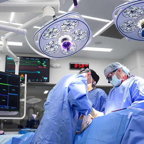Cardiovascular surgeons in operating room performing a procedure on patient.