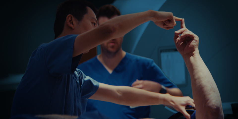 Healthcare professional guiding a patient through a hand and arm mobility assessment in a clinical setting.