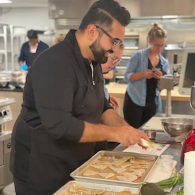 Chef preparing food while smiling in the kitchen