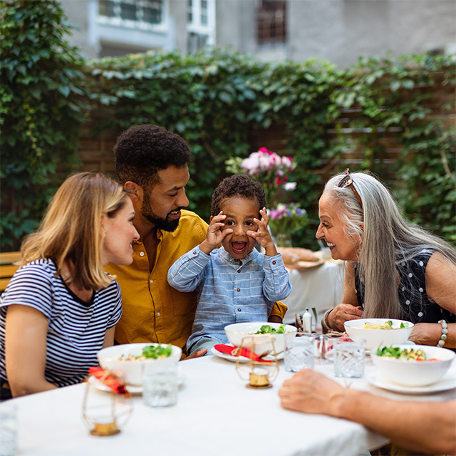 A family gathered around a table, sharing a meal and enjoying each other's company.
