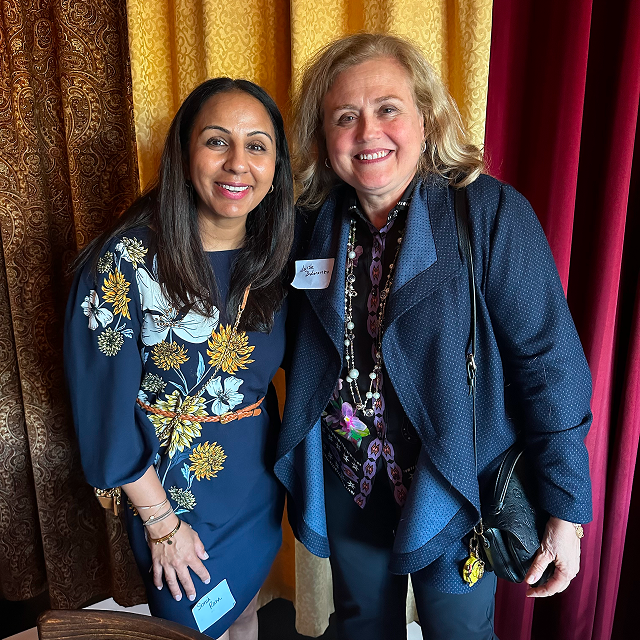 Two attendees posing together for a photo at a residency celebration event