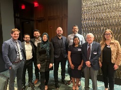 Attendees of the Detroit STEMI AngioClub Conference stand together in a lobby, engaging in discussions on STEMI care advancements.