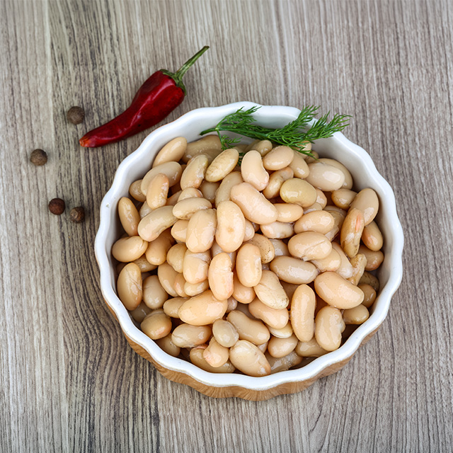 Bowl of white beans with fresh dill and red pepper on a wooden table, highlighting a nutritious ingredient for healthy meals.