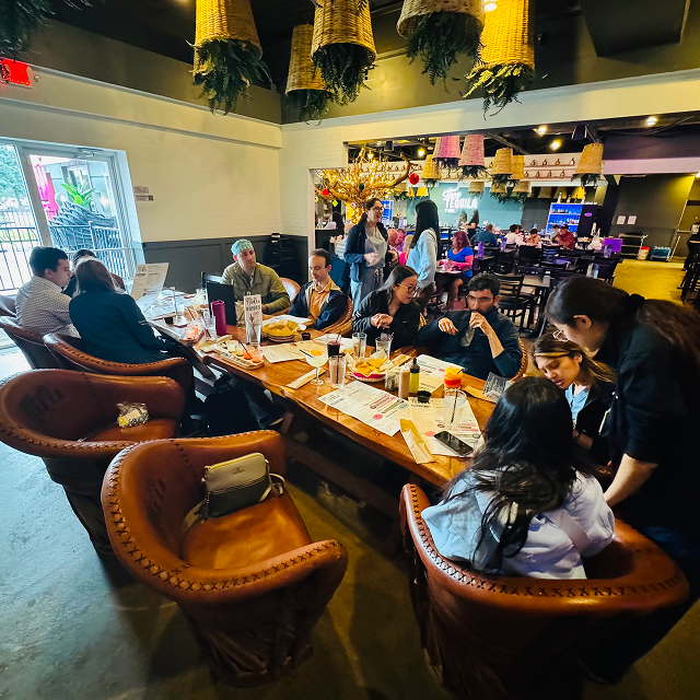 Residents and attendees gathered around a restaurant table during a residency community gathering