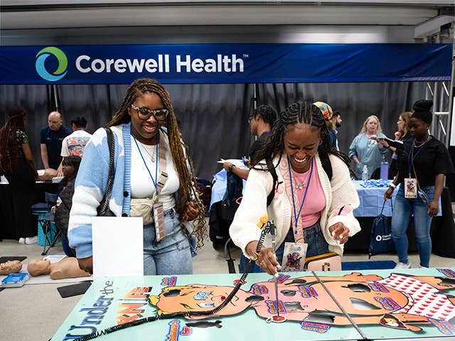 Two women standing at a table playing a game.