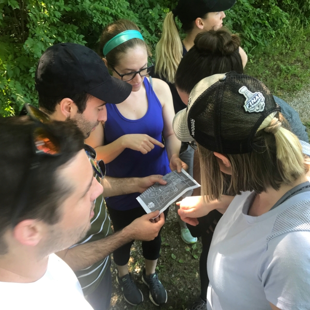 Residents in a circle looking at a map during an outdoor training activity