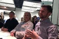 A group of faculty members from Graduate Medical Education Southeast Michigan sitting at a table with microphones.
