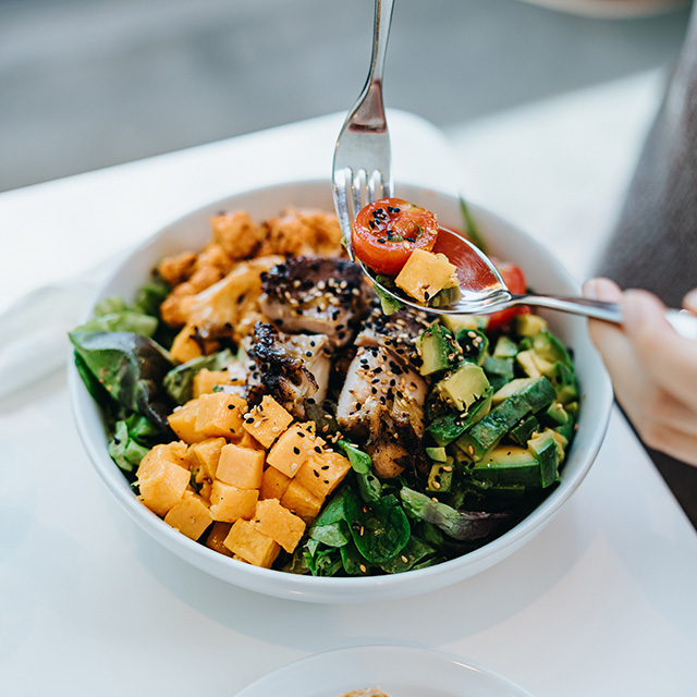 A white bowl with a salad inside