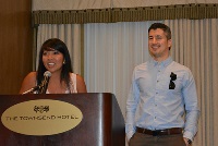 A man stands confidently before a presentation screen, representing Graduate Medical Education in Southeast Michigan residencies.