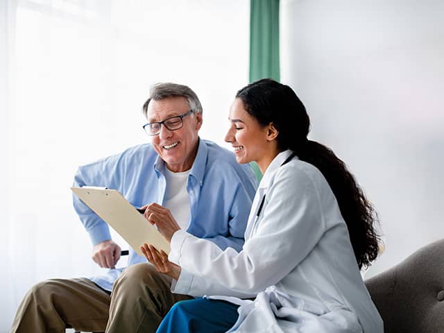 Female doctor walking a patient through something on a tablet