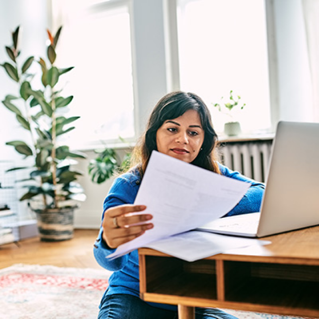 female patient reading her paperwork in front of a laptop 