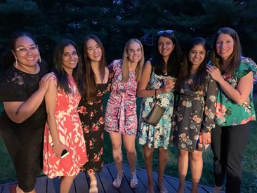 A group of women joyfully posing together on a deck, embodying camaraderie and wellness in a vibrant setting.