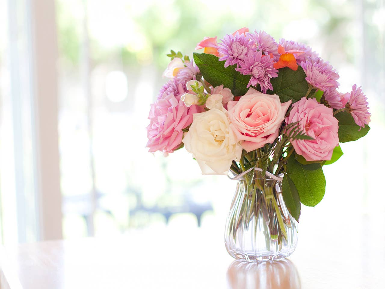 A vase filled with colorful flowers sits elegantly on a wooden table.