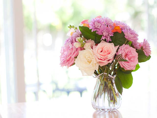 A vase filled with colorful flowers sits elegantly on a wooden table.