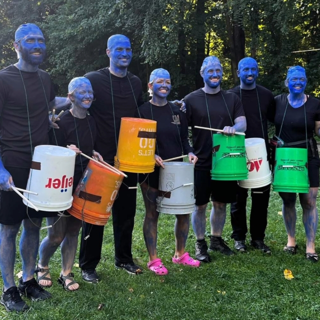 Group of residents looking like the Blue Man Group with buckets and drum sticks