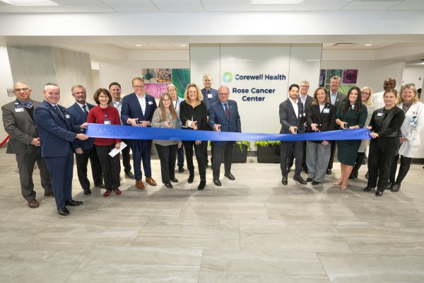 Group of people cutting a ribbon at a new building
