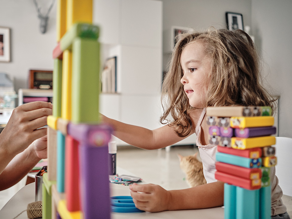 Young girl learning and developing new skills playing with interactive toys