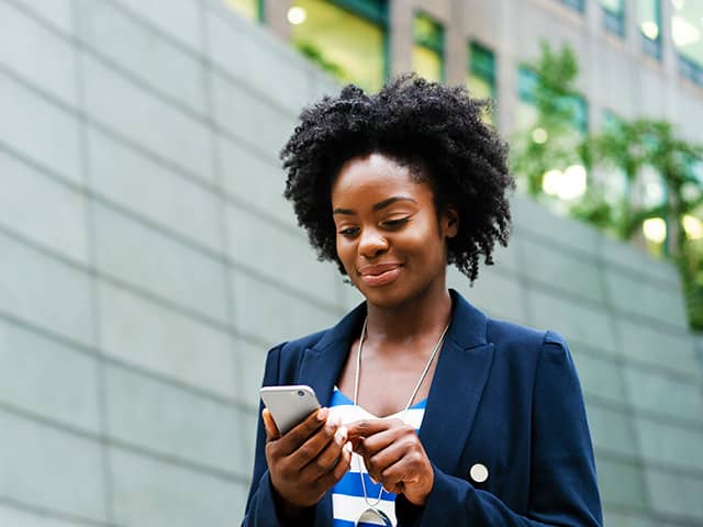Person using a smartphone outdoors to access health information, manage appointments, or view medical records online.