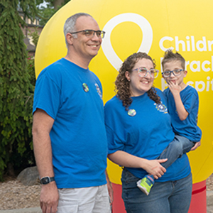 couple holding a small boy all wearing blue shirts