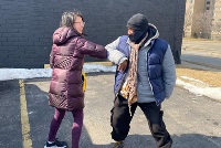 A man and woman stand together in a parking lot, symbolizing community engagement and diversity in CPR training initiatives.