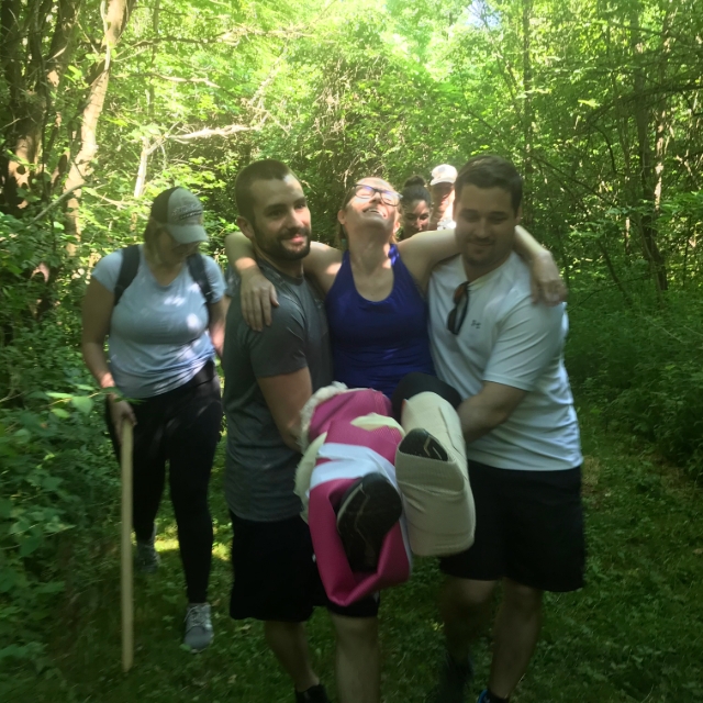 Group of residents carrying an injured fellow resident during a training activity outside
