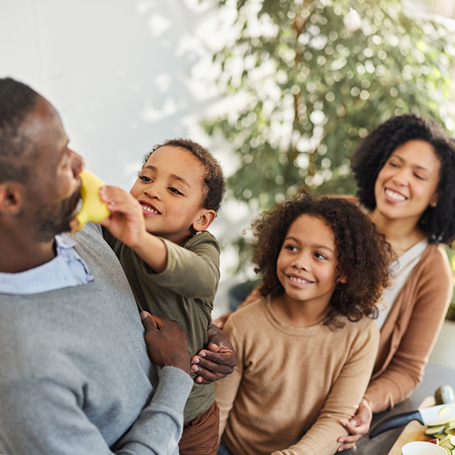 Family sharing fresh fruit at the table, encouraging healthy eating habits and enjoying nutritious foods together.