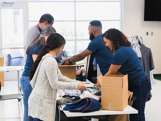 People are engaged in packing boxes within a room, working together.