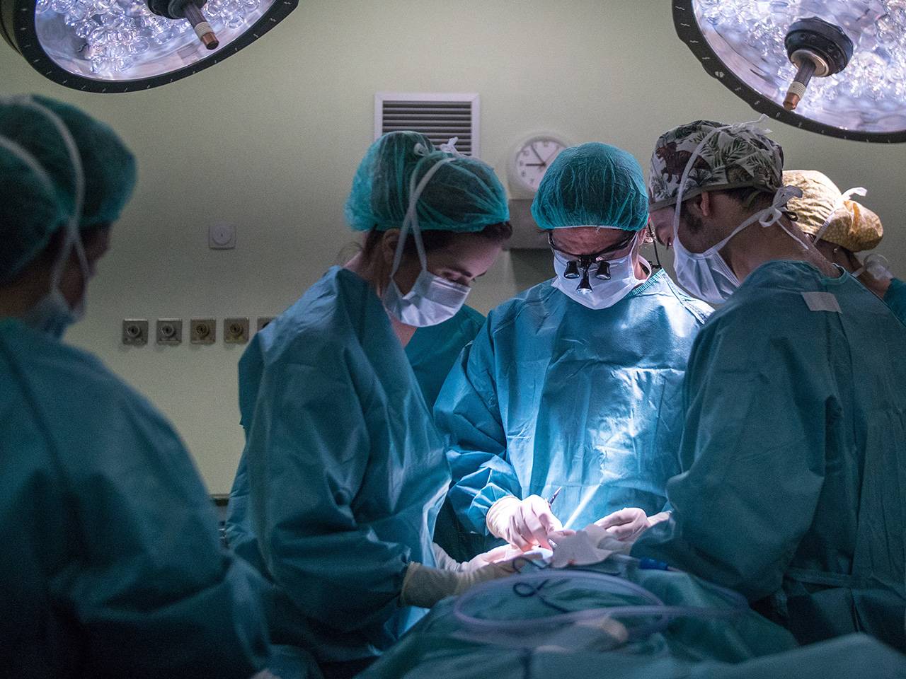 Group of surgery team members and surgeons performing surgery in operating room