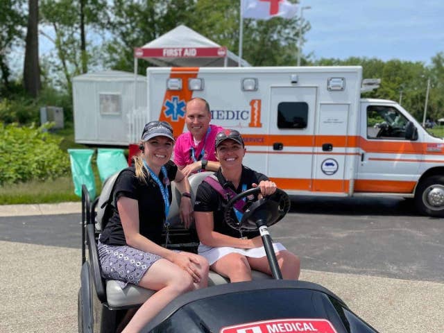 Medical staff at the golf outing posing for a group photo on a golf cart