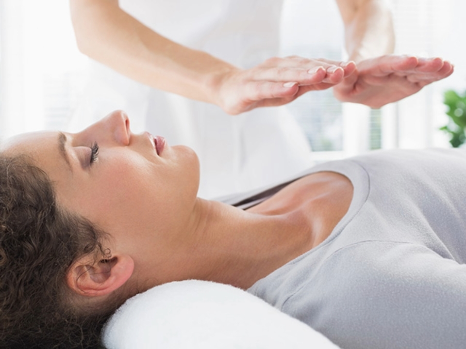 A professional providing reiki on a patient