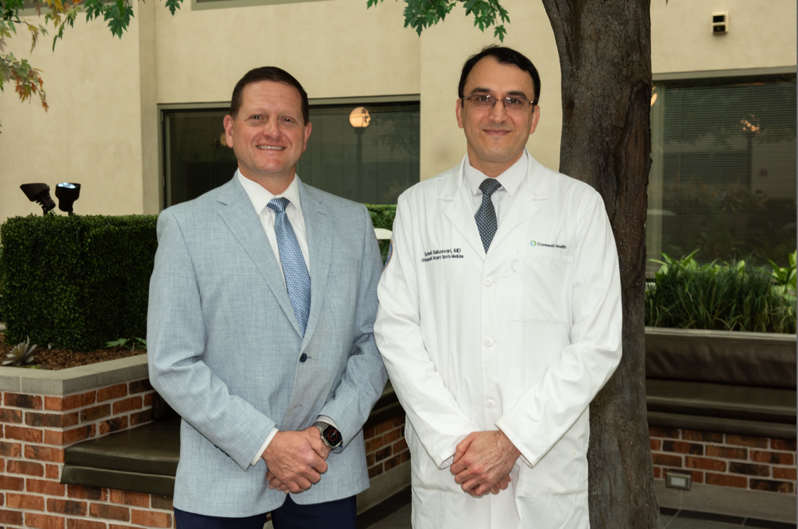 Two men in white lab coats standing together, suggesting a collaborative or professional atmosphere.