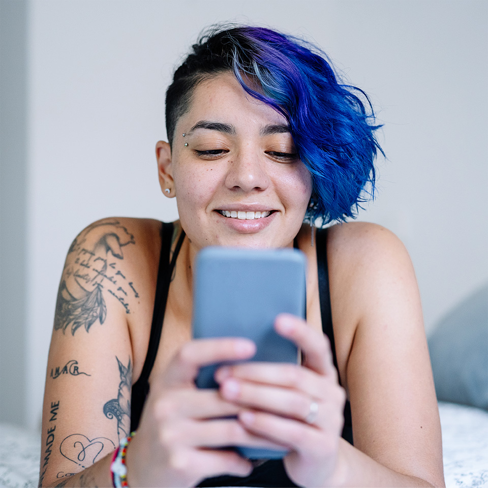 Smiling young woman looks at her phone