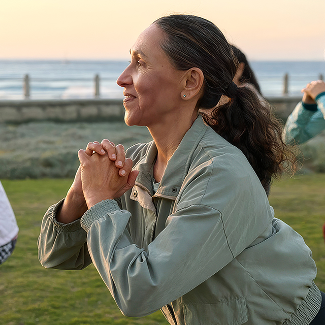 People performing outdoor squats near the beach, highlighting exercise, mobility, and activities linked to hip pain causes and treatment.