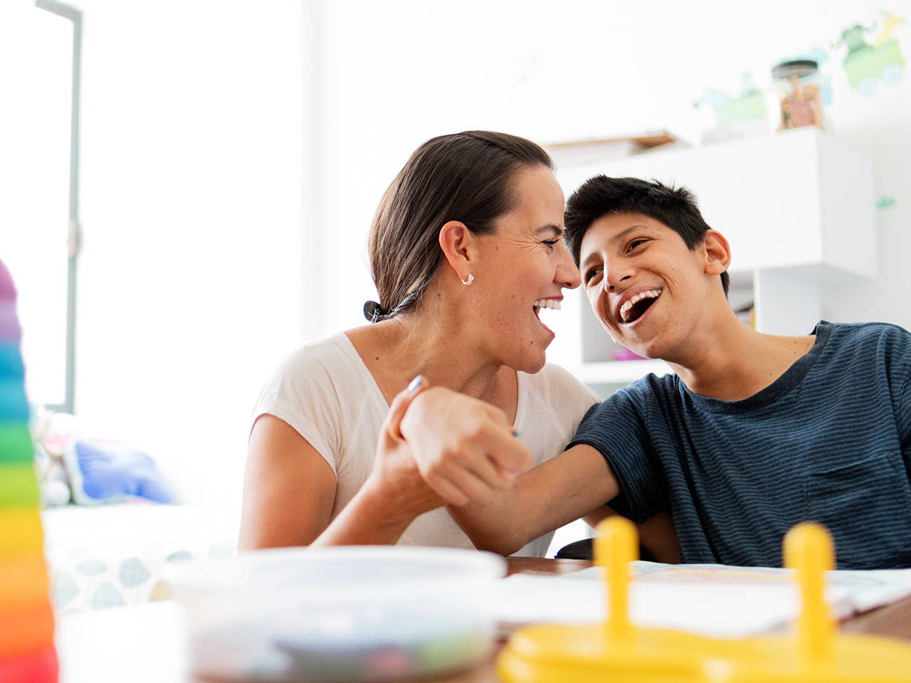Preteen boy and his mother smiling and interacting at the table.